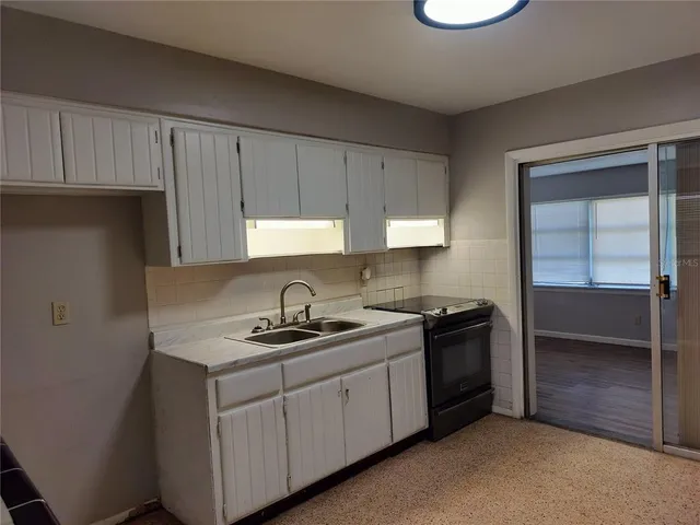 a kitchen with stainless steel appliances granite countertop a sink stove and cabinets