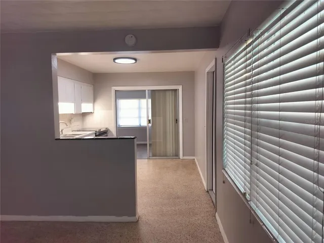 a view of a hallway to a house with wooden floor