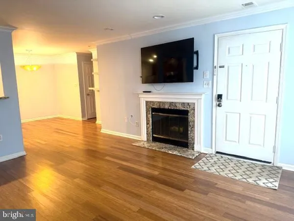 a view of a livingroom with wooden floor and a fireplace