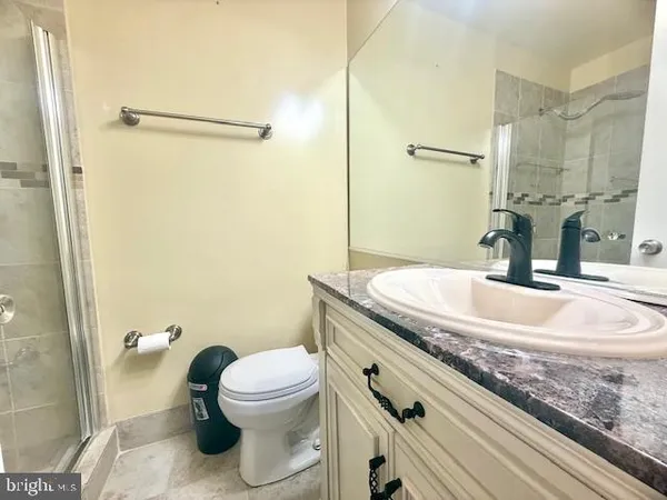 a bathroom with a granite countertop sink toilet and shower