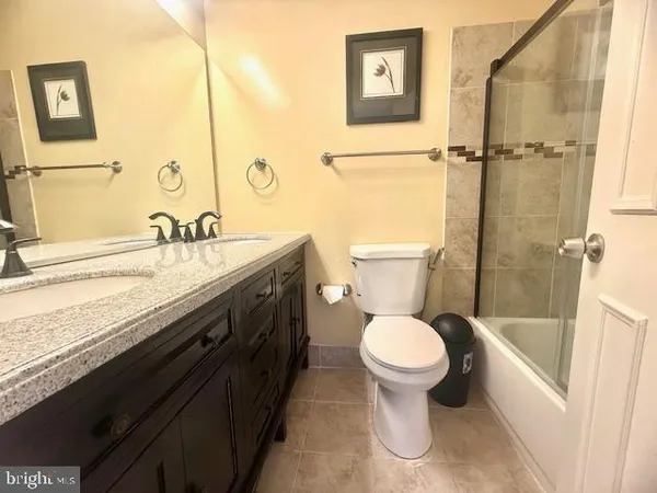 a bathroom with a granite countertop toilet sink and mirror