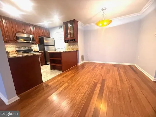 a kitchen with wooden floors and wooden cabinets