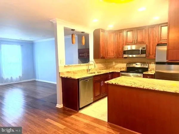 a kitchen with stainless steel appliances granite countertop a sink stove and wooden floor