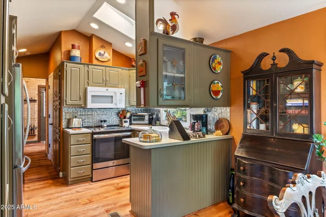 a living room with stainless steel appliances kitchen island granite countertop a stove and a sink