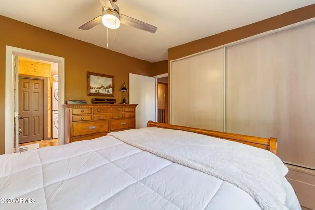a bedroom with a bed and a flat tv screen on dresser