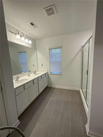 a bathroom with a double vanity sink and mirror