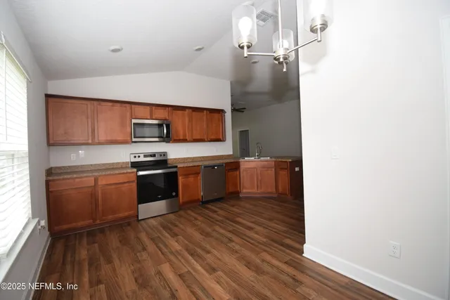 a kitchen with stainless steel appliances a refrigerator and a stove top oven