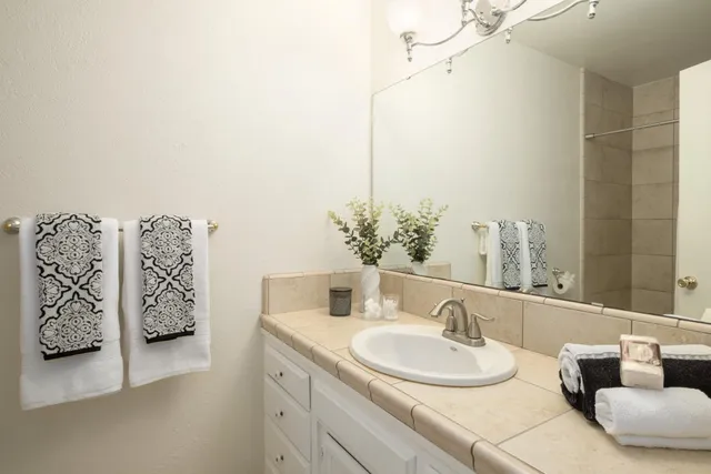 a bathroom with a granite countertop sink and a mirror