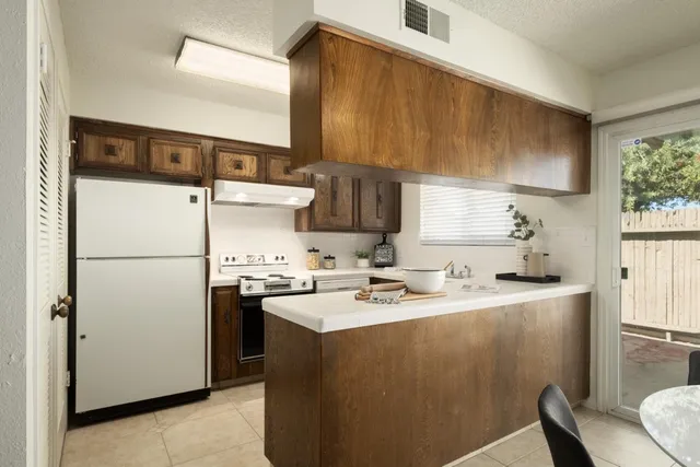 a kitchen with stainless steel appliances a refrigerator a sink a stove and white cabinets
