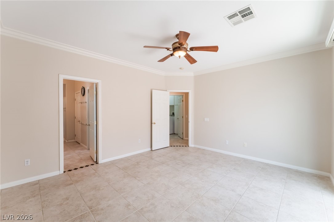 10481 Riverside Park Avenue Las Vegas, NV 89135 - Photo 18 of 51 Unfurnished bedroom featuring ornamental molding, ceiling fan, ensuite bath, and light tile patterned floors