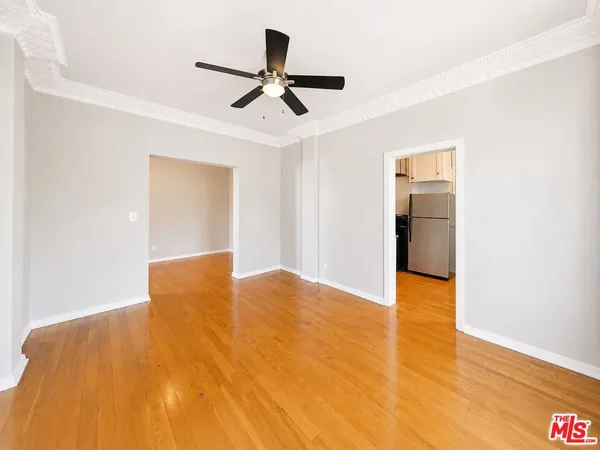 a view of empty room with wooden floor