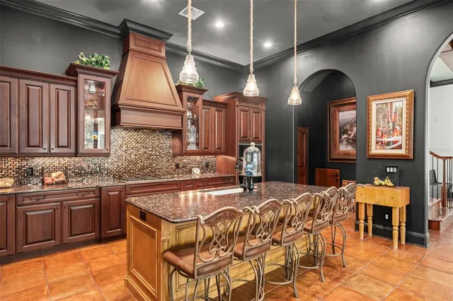 a dining hall with stainless steel appliances granite countertop a sink a stove and a wooden floors