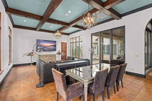 a dining room with furniture a flat screen tv and a chandelier