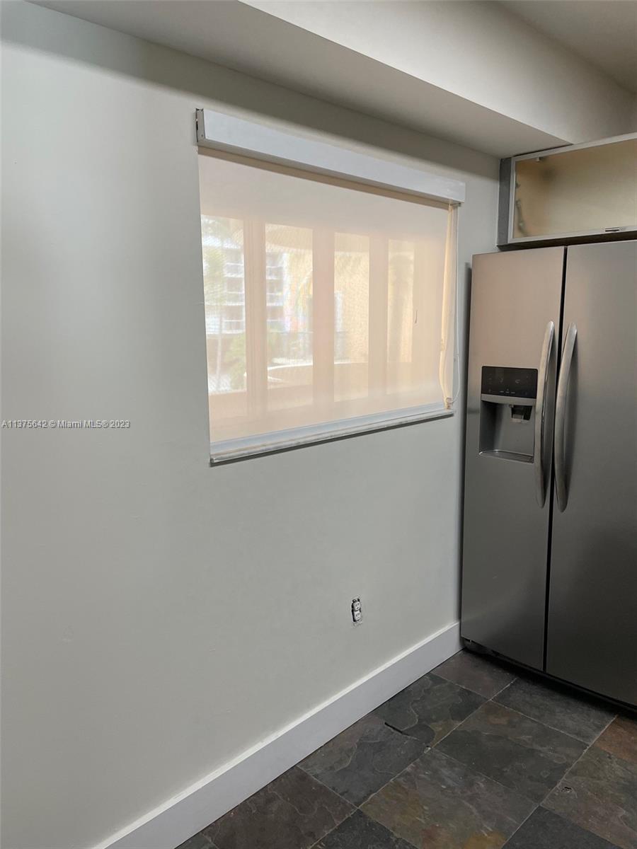 Normandy Beach Surfside, FL 33154 - Photo 11 of 32 a view of a kitchen with a refrigerator and window