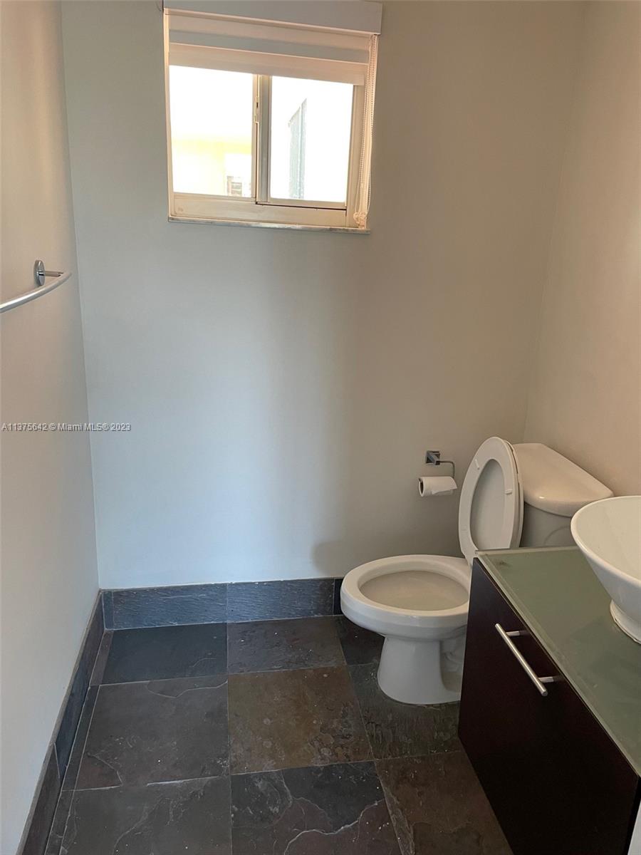 Normandy Beach Surfside, FL 33154 - Photo 23 of 32 a bathroom with a toilet sink and window