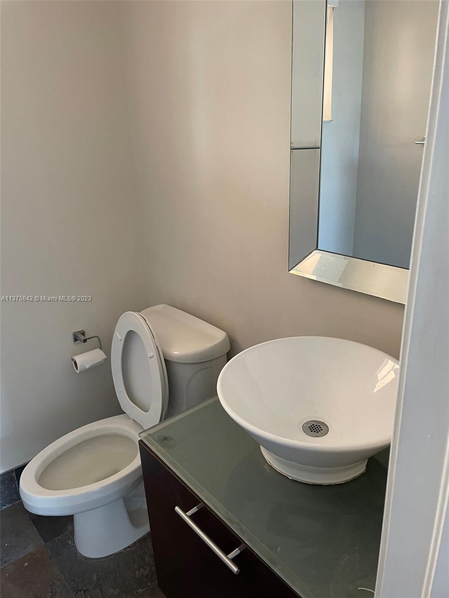 Normandy Beach Surfside, FL 33154 - Photo 24 of 32 a bathroom with a sink and a mirror