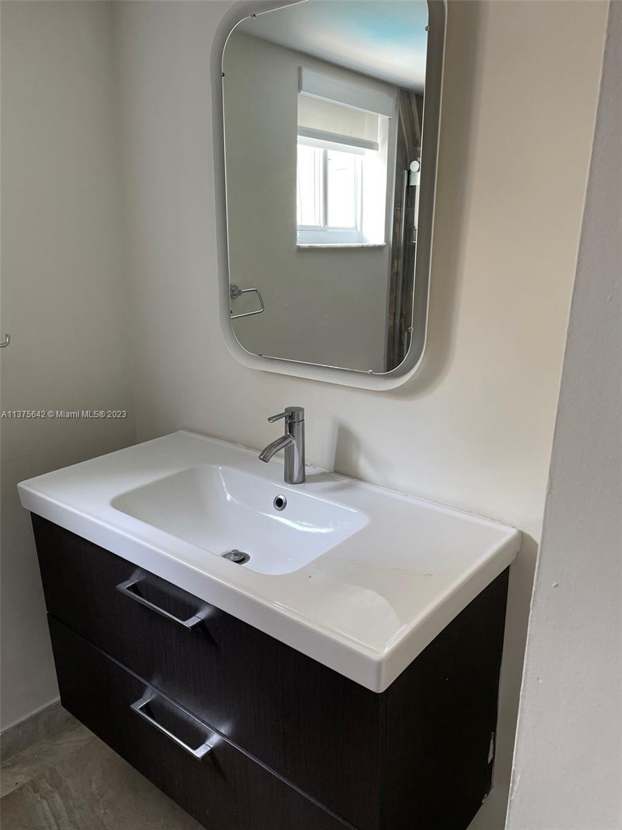 Normandy Beach Surfside, FL 33154 - Photo 31 of 32 a bathroom with a sink and a mirror