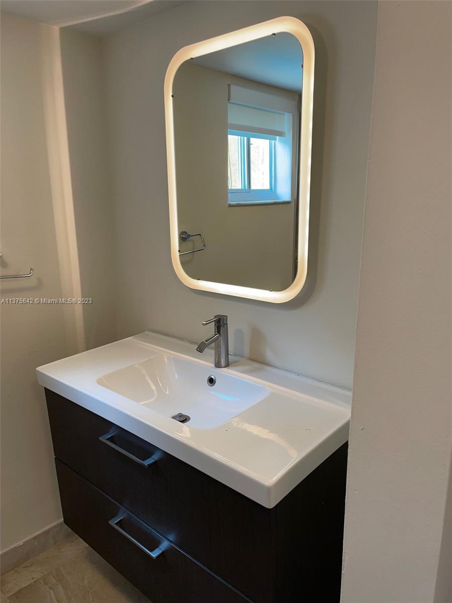 Normandy Beach Surfside, FL 33154 - Photo 32 of 32 a bathroom with a sink vanity and a mirror