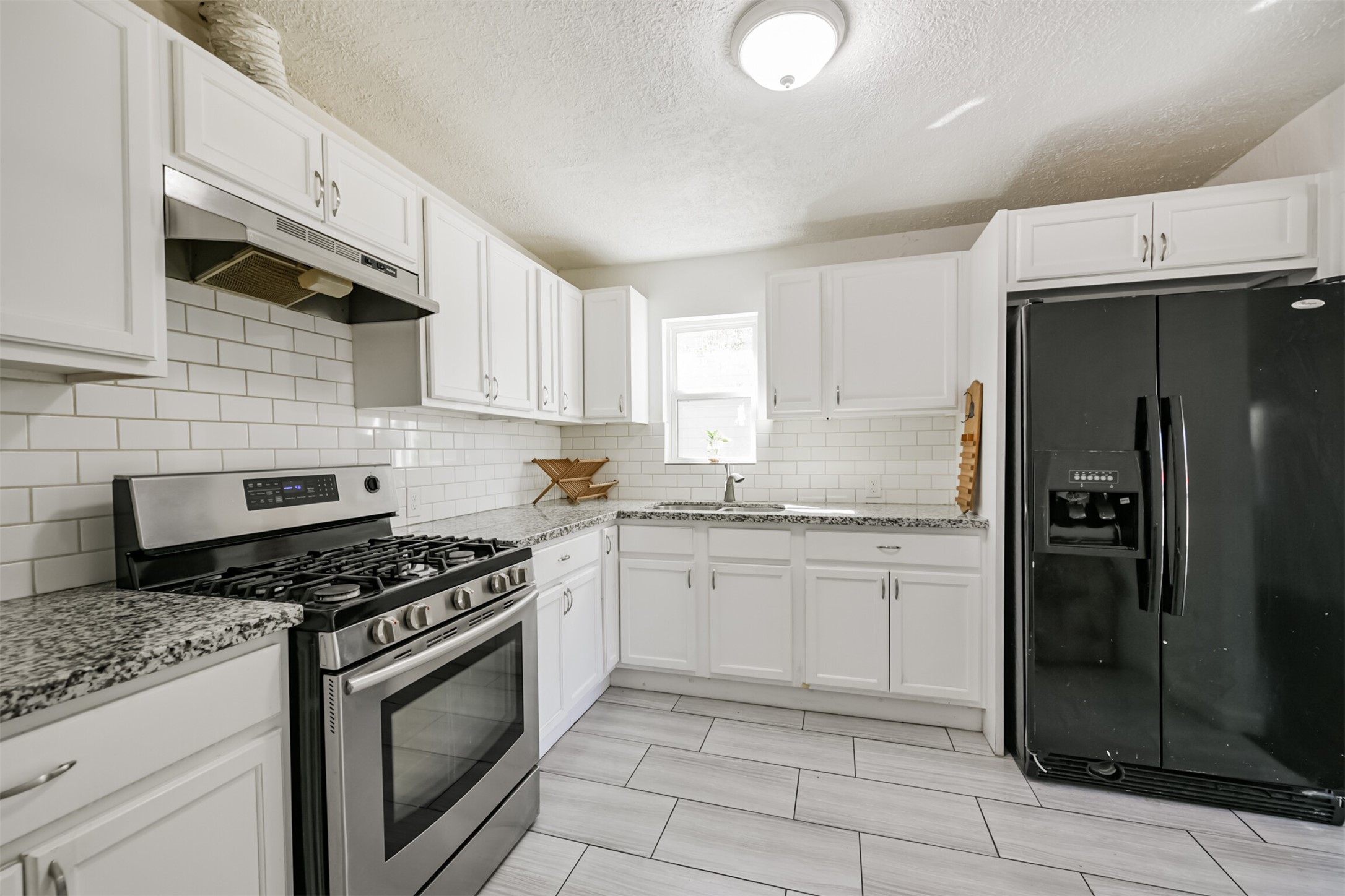 7546 Greendowns Street Houston, TX 77087 - Photo 18 of 33 a kitchen with granite countertop a stove sink and cabinets