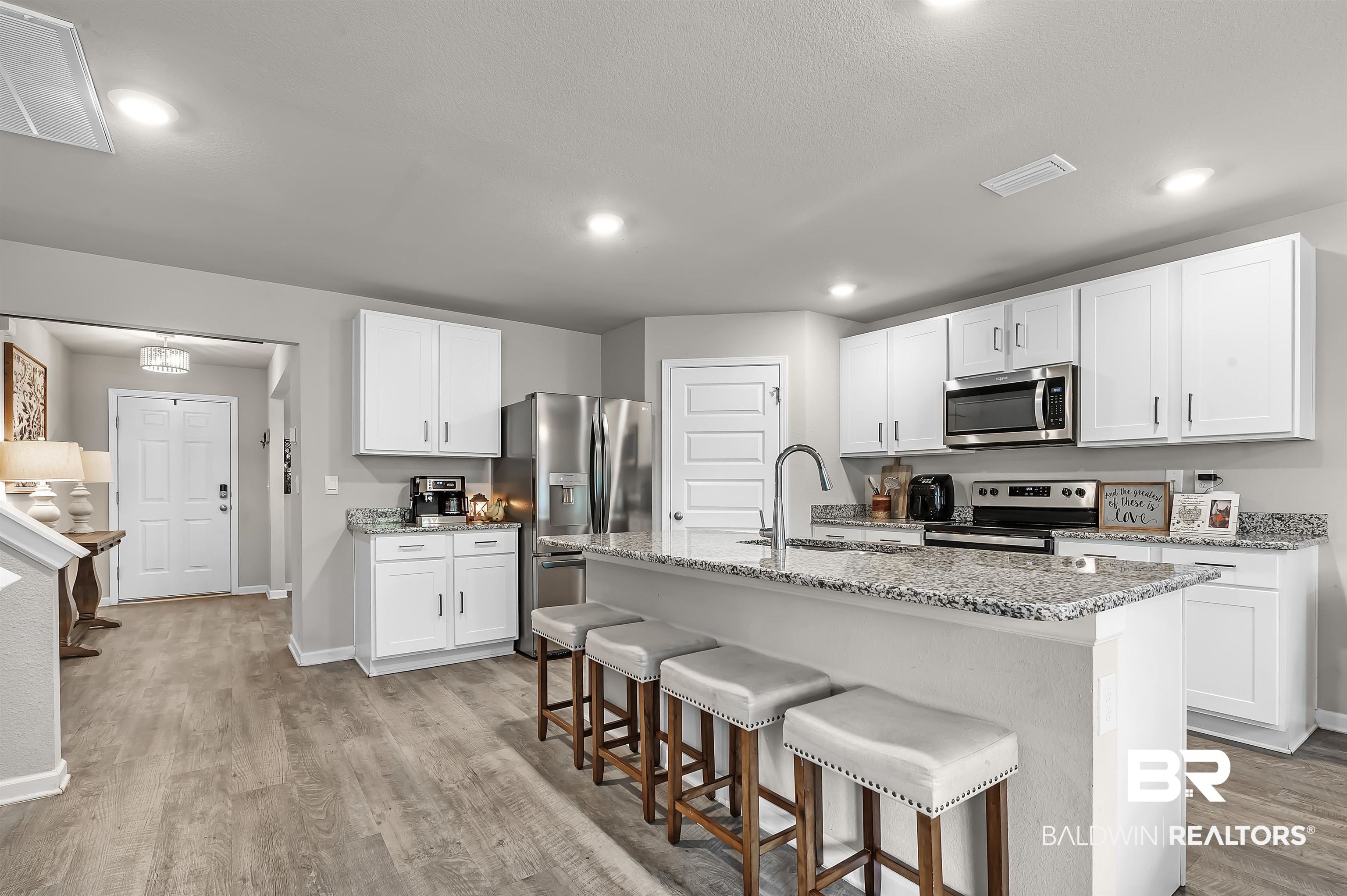 24549 Broken Sound Loop Orange Beach, AL 36561 - Photo 16 of 57 Kitchen featuring a center island with sink, appliances with stainless steel finishes, sink, and white cabinetry