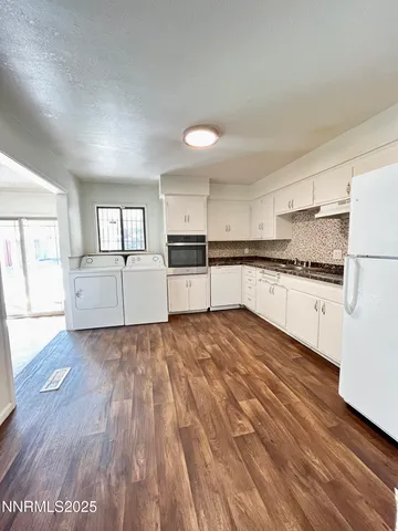 a large kitchen with cabinets wooden floor and stainless steel appliances