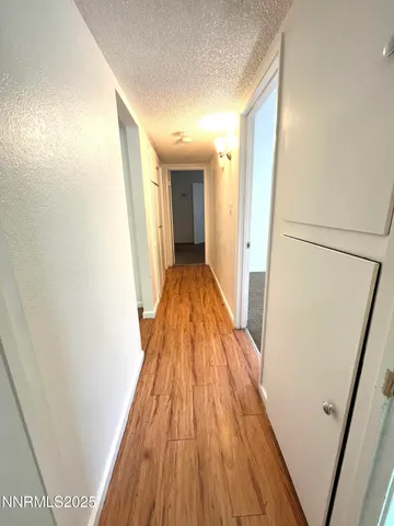 a view of a hallway with wooden floor