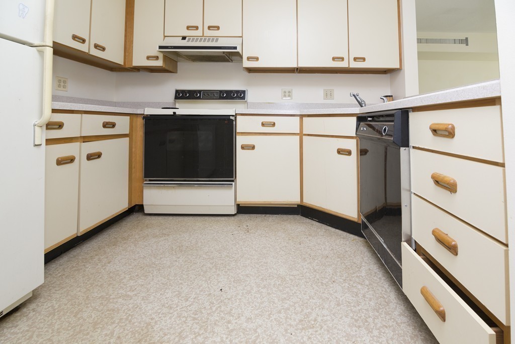 50 South Common Street, Unit 403 Lynn, MA 01902 - Photo 9 of 16 a kitchen with granite countertop white cabinets and white appliances