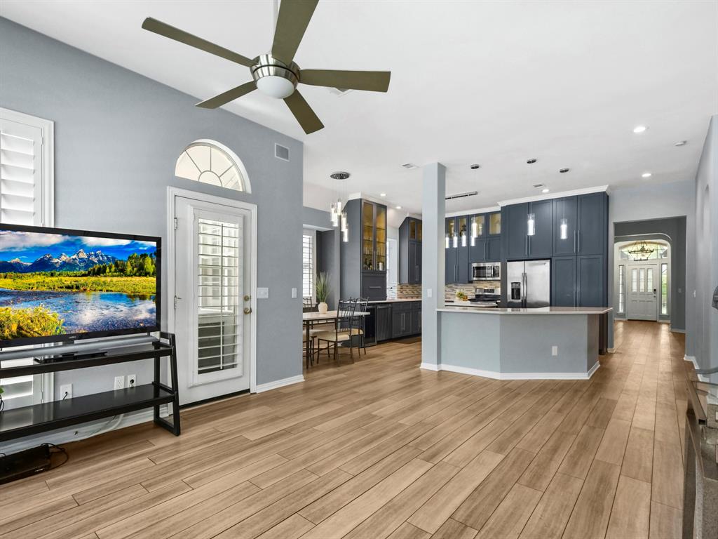 4025 Azure Lane Addison, TX 75001 - Photo 9 of 40 a view of a living room and kitchen with furniture wooden floor and fan