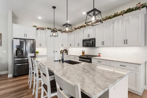 a kitchen with granite countertop a table chairs microwave and cabinets