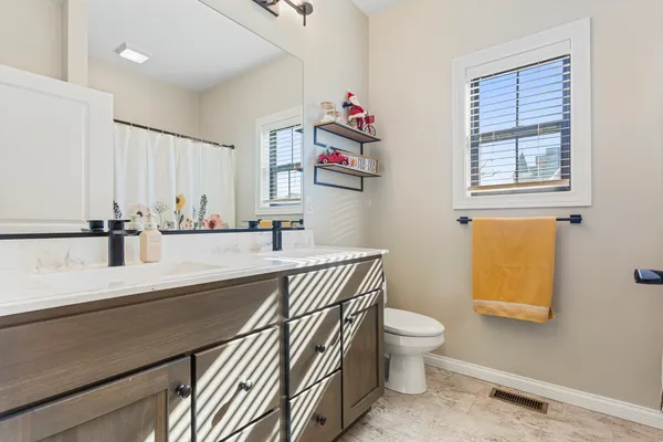 a bathroom with a sink a toilet and a window