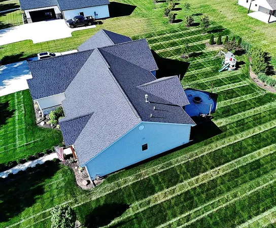 an aerial view of a house with a yard