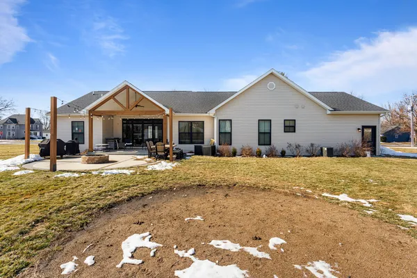 a view of a white house with a large pool and a yard with plants