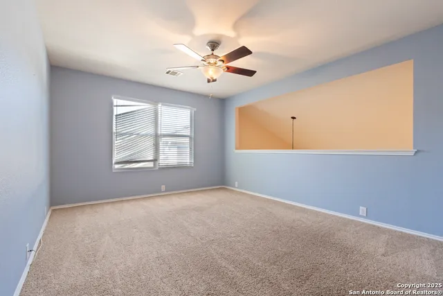 an empty room with windows and fan