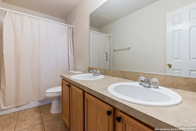 a bathroom with a granite countertop sink toilet and a mirror