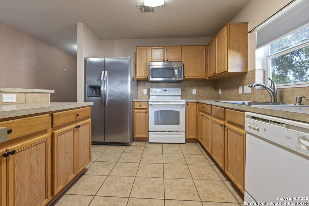 5109 Brookline Schertz, TX 78108 - Photo 6 of 35 a kitchen with stainless steel appliances granite countertop a refrigerator and a stove top oven