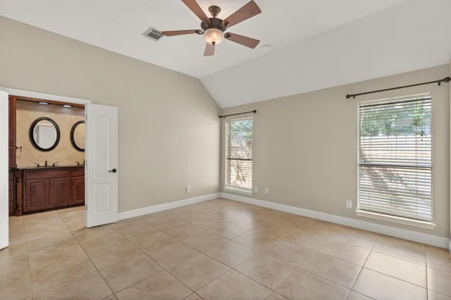 a view of an empty room with window and a bathroom