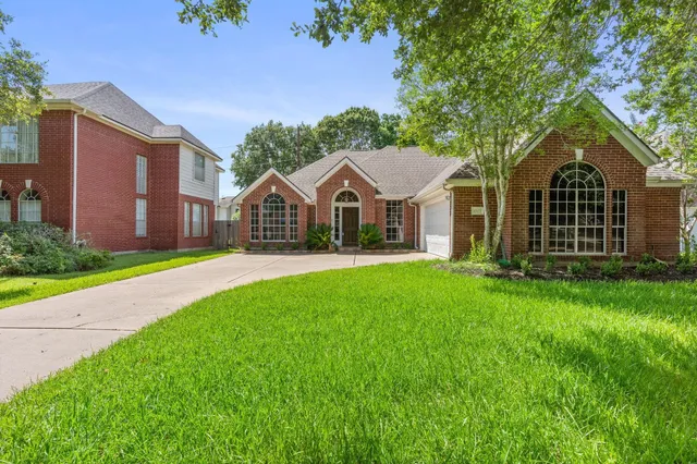 an aerial view of residential houses with outdoor space and trees