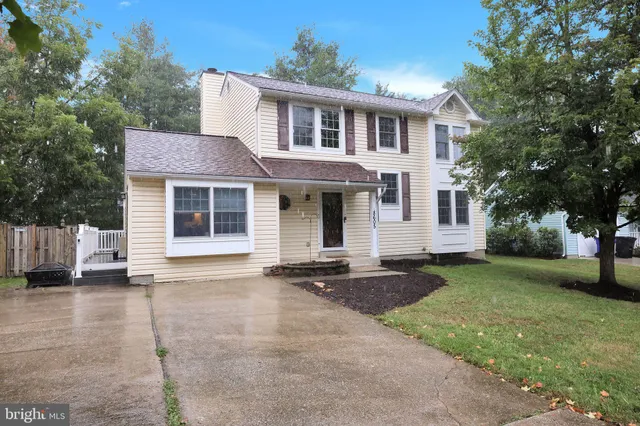 a front view of a house with a garden and trees