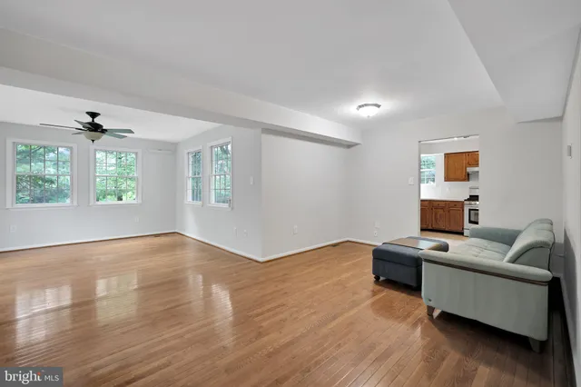 a view of a livingroom with furniture wooden floor and windows