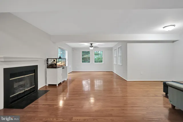 a view of empty room with wooden floor and fireplace