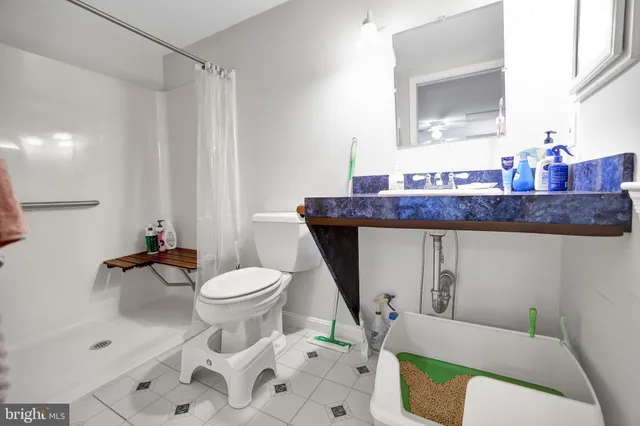 a bathroom with a granite countertop toilet a sink and a mirror