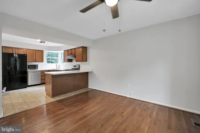 a kitchen with stainless steel appliances kitchen island wooden cabinets and granite counter tops