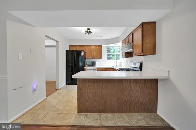 a kitchen with a wooden floor and electronic appliances