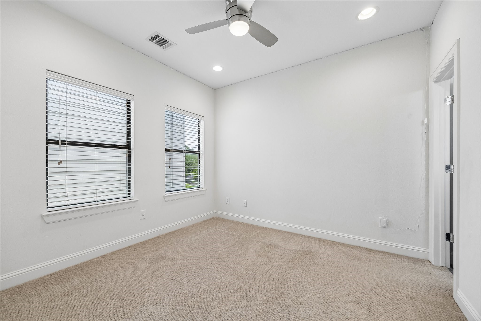 734 West 20th Street, Unit A Houston, TX 77008 - Photo 16 of 23 Third-floor bedroom features plush carpeting, recessed lighting & great natural light, offering a comfortable and versatile space.