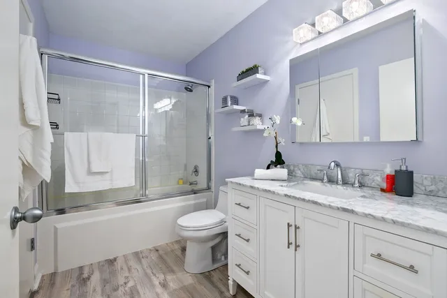 a bathroom with a granite countertop sink a toilet and a mirror