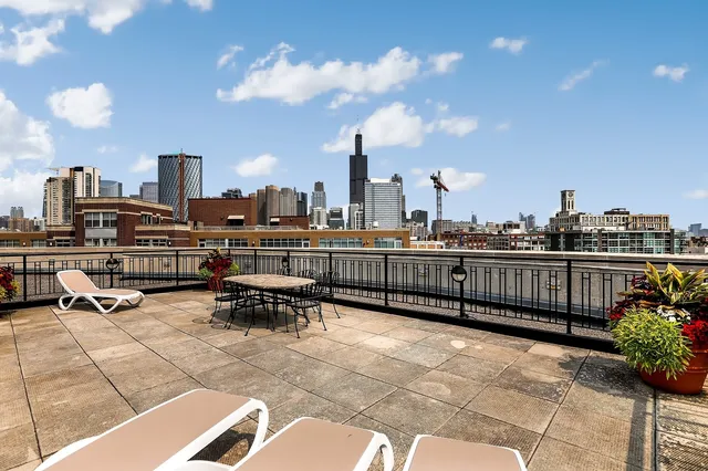 a view of a terrace with lawn chairs and iron fence