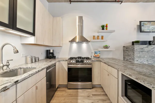 a kitchen with stainless steel appliances granite countertop a sink stove and cabinets