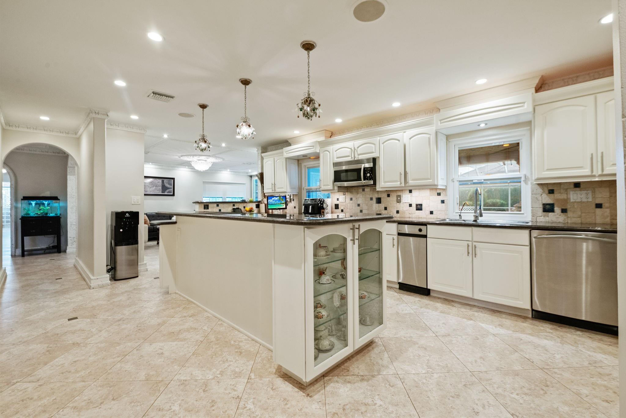 17501 Southwest 54th Street Southwest Ranches, FL 33331 - Photo 16 of 39 a kitchen with stainless steel appliances kitchen island granite countertop a sink a stove a refrigerator cabinets and chairs