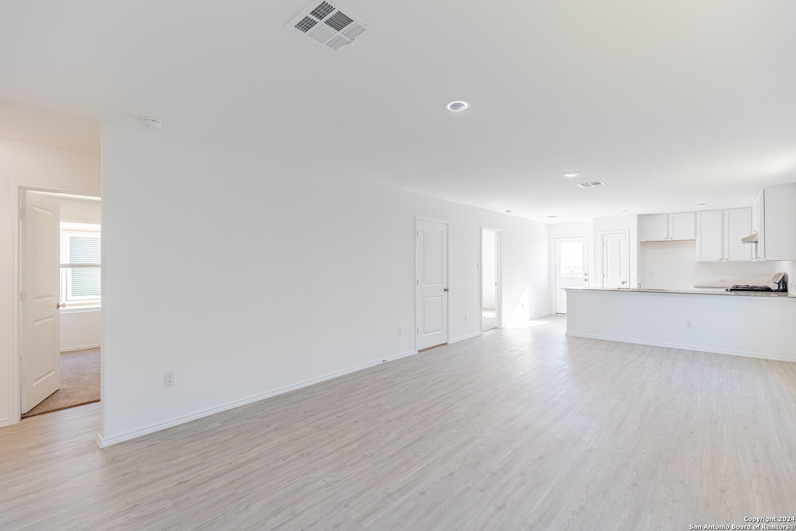 1631 Knoll Ridge New Braunfels, TX 78130 - Photo 5 of 29 a view of an empty room and kitchen with wooden floor