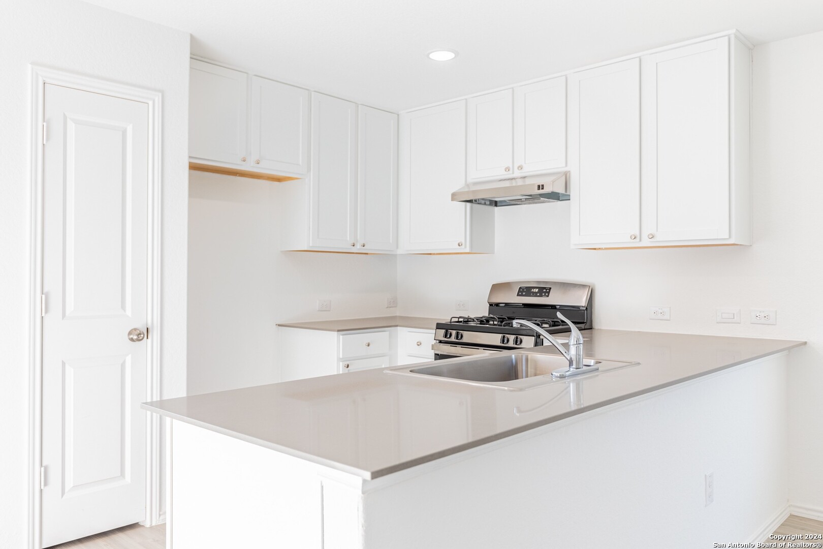 1631 Knoll Ridge New Braunfels, TX 78130 - Photo 9 of 29 a kitchen with a sink a stove and cabinets